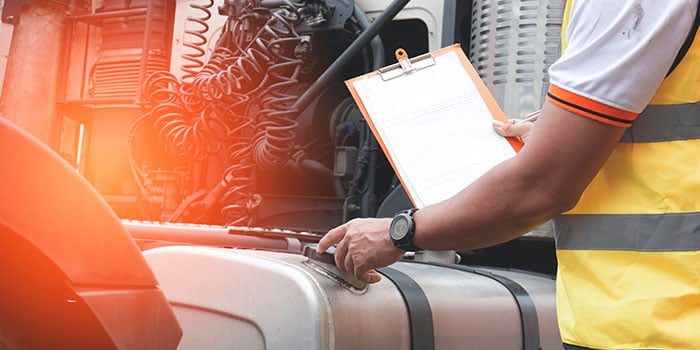 an employee performs an inspection on a semi truck